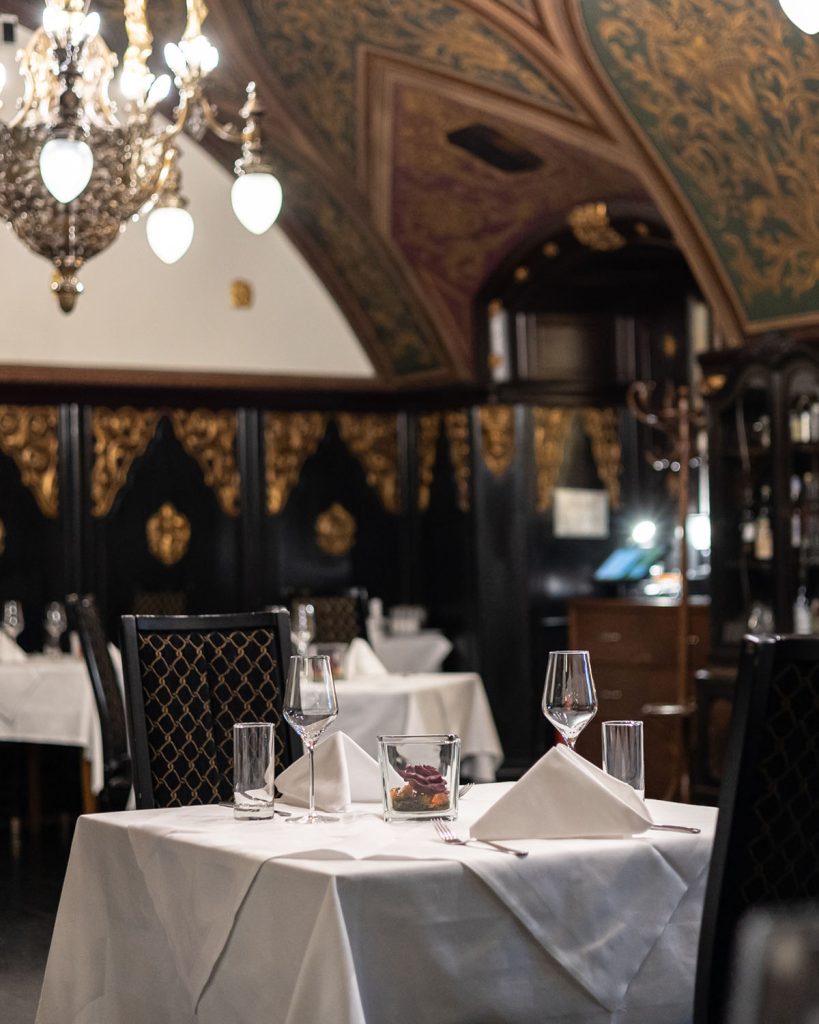 Einblick in das den Salon Ziehrer des Wiener Rathauskeller, weiß gedeckter Tisch mit Weingläsern und Tischdekoration